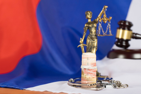 Money on a flag of Russian Federation. Statue of Themis and judge's gavel in the background.の写真素材