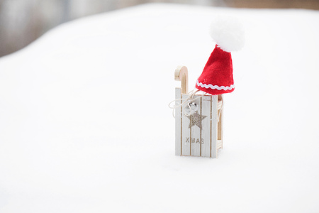 Winter holidays background:  Santa Claus hat on a wooden made sleigh. Closeup