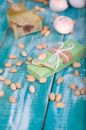 Almond turron covered by pistachio chocolate on a wooden surface. Closeupの写真素材