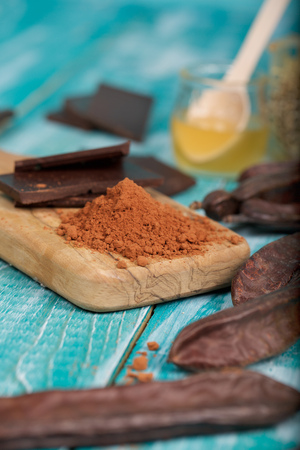 Carob pods and powder on a wooden surface. Closeupの写真素材