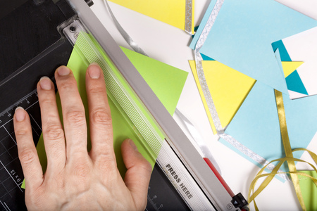 Colourful paper trimming process. Closeup