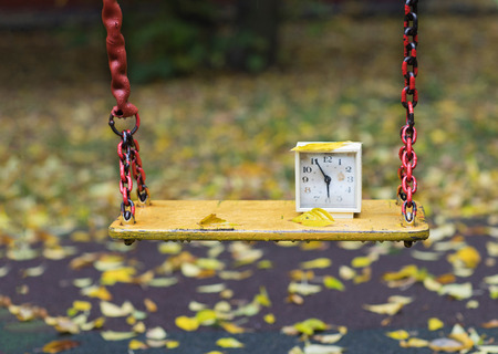 Old square alarm clock on a swing. Closeupの写真素材
