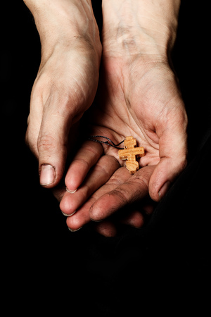 Wooden handmade cross in the palm of a peasant woman. Closeupの写真素材