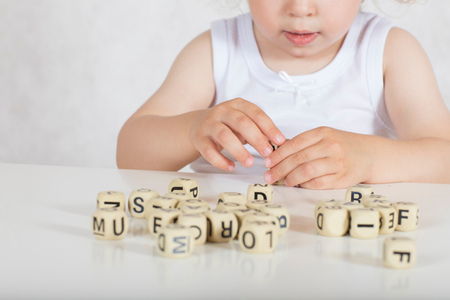 Small girl of two years composes words from letters. Closeupの写真素材