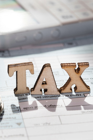 Word TAX composed of wooden letters. Coins, papers, pen in the background. Closeupの写真素材