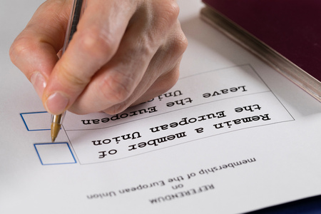 Referendum ballot paper, black pen, and passport on the table. Closeup