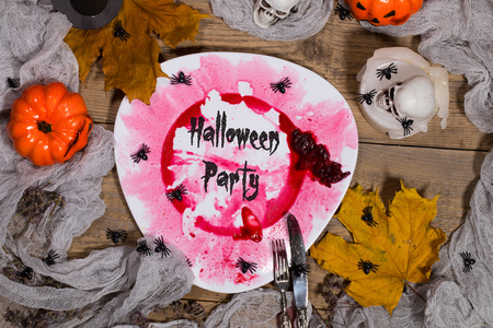 Dirty red plate with silver cutlery on Halloween table. Closeupの写真素材