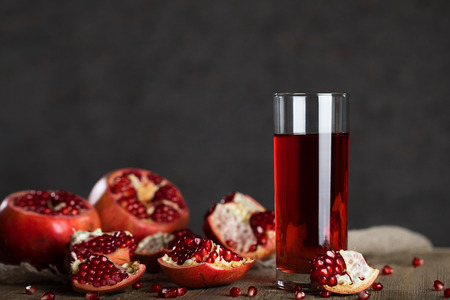 Glass of pomegranate juice on a wooden surface. Closeupの写真素材