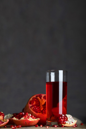 Glass of pomegranate juice on a wooden surface. Closeupの写真素材
