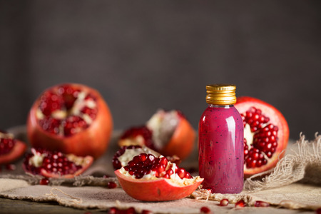 Glass of pomegranate seed body scrub on a wooden surface. Closeupの写真素材