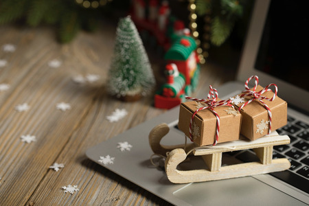 Small wooden sleigh with Christmas presents on a laptop. Closeupの写真素材