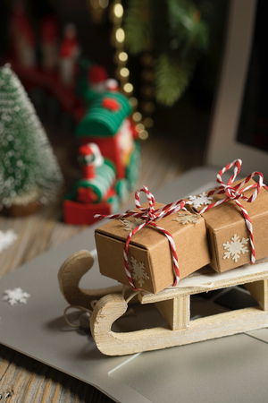Small wooden sleigh with Christmas presents on a laptop. Closeupの写真素材