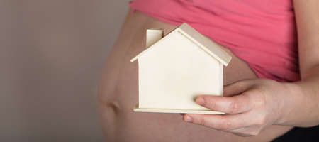 Young pregnant between 30 and 35 years old woman keeps small handmade house. Closeupの写真素材