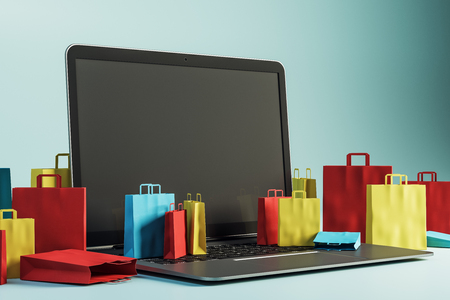 Empty laptop with tiny shopping bags on blue background. Online shopping and internet concept. Mock up, 3D Rendering の写真素材