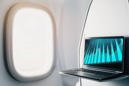 Laptop closeup inside airplane with forex graph on screen. Financial market trading concept. 3d rendering.の写真素材