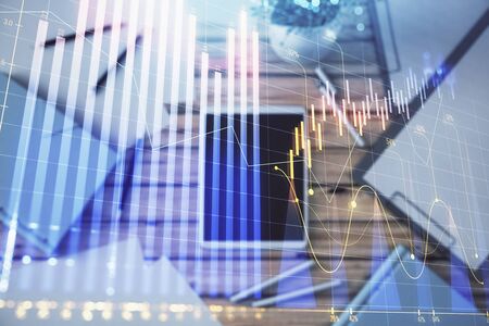 Double exposure of forex graph on digital tablet laying on table background. Concept of market analysisの写真素材