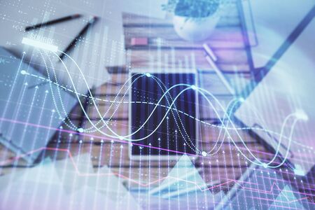 Double exposure of forex graph on digital tablet laying on table background. Concept of market analysisの写真素材