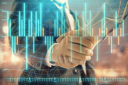 Double exposure of financial chart on cityscape background with two businessmen handshake. Concept of financial analysis and investment opportunitiesの写真素材