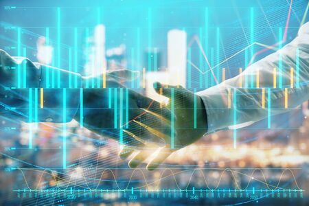 Double exposure of financial chart on cityscape background with two businessmen handshake. Concept of financial analysis and investment opportunitiesの写真素材