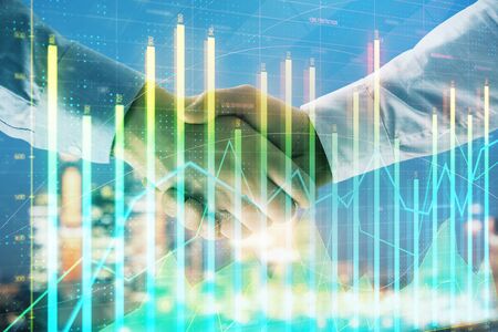 Double exposure of financial chart on cityscape background with two businessmen handshake. Concept of financial analysis and investment opportunitiesの写真素材