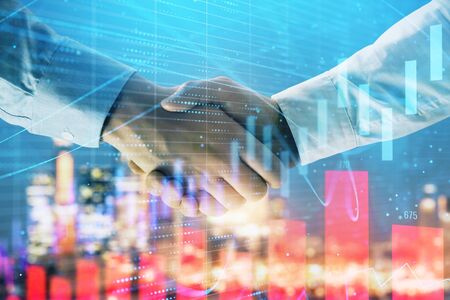 Double exposure of financial chart on cityscape background with two businessmen handshake. Concept of financial analysis and investment opportunitiesの写真素材