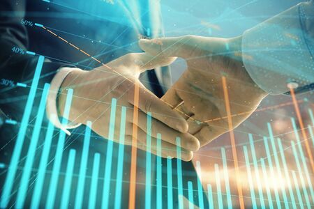 Double exposure of financial chart on cityscape background with two businessmen handshake. Concept of financial analysis and investment opportunitiesの写真素材