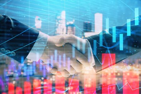 Double exposure of financial graph on cityscape background with two businessman handshake. Concept of stock market dealの写真素材