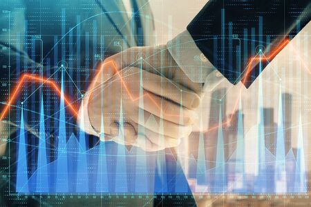 Double exposure of financial graph on cityscape background with two businessman handshake. Concept of stock market dealの写真素材