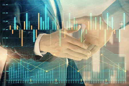 Double exposure of financial graph on cityscape background with two businessman handshake. Concept of stock market dealの写真素材