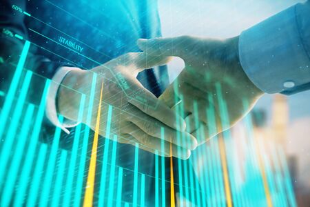 Double exposure of financial graph on cityscape background with two businessman handshake. Concept of stock market dealの写真素材