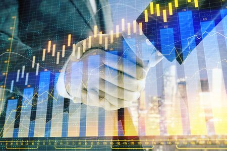 Double exposure of financial chart on cityscape background with two businessmen handshake. Concept of financial analysis and investment opportunitiesの写真素材