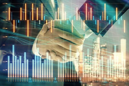 Double exposure of financial chart on cityscape background with two businessmen handshake. Concept of financial analysis and investment opportunitiesの写真素材