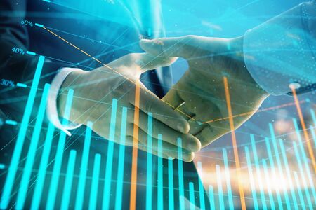 Double exposure of financial chart on cityscape background with two businessmen handshake. Concept of financial analysis and investment opportunitiesの写真素材