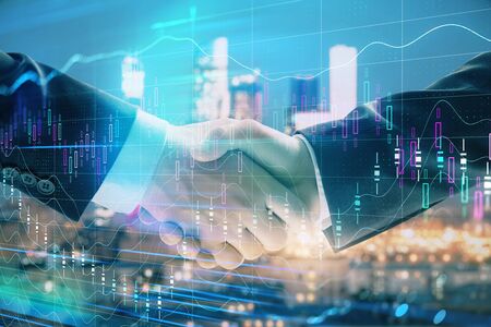 Double exposure of financial graph on cityscape background with two businessman handshake. Concept of stock market dealの写真素材