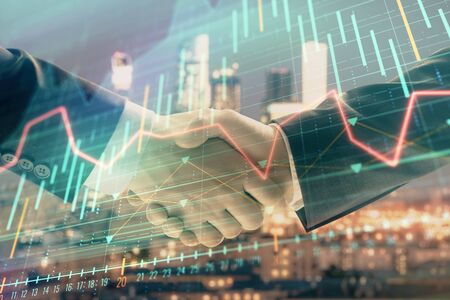 Double exposure of financial graph on cityscape background with two businessman handshake. Concept of stock market dealの写真素材