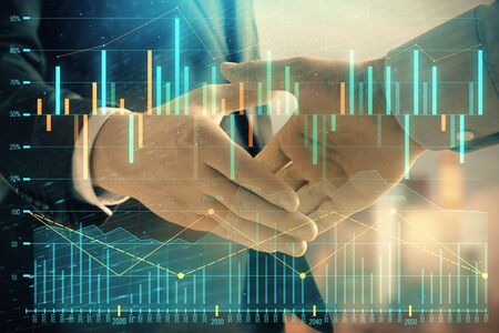 Double exposure of financial graph on cityscape background with two businessman handshake. Concept of stock market dealの写真素材