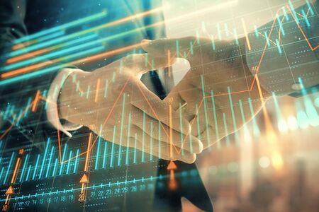 Double exposure of financial graph on cityscape background with two businessman handshake. Concept of stock market dealの写真素材