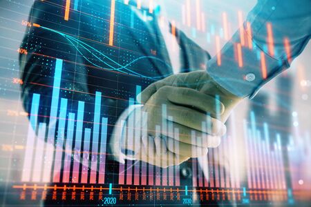 Double exposure of financial graph on cityscape background with two businessman handshake. Concept of stock market dealの写真素材