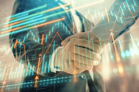 Double exposure of financial graph on cityscape background with two businessman handshake. Concept of stock market dealの写真素材