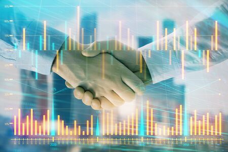 Double exposure of financial graph on cityscape background with two businessman handshake. Concept of stock market dealの写真素材