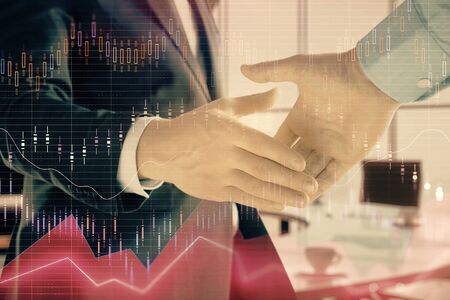 Multi exposure of financial graph on office background with two businessmen handshake. Concept of success in businessの写真素材
