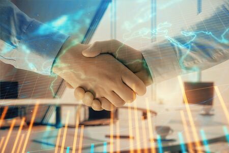 Multi exposure of financial chart and map on office background with two businessmen handshake. Concept of success in businessの写真素材