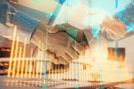 Multi exposure of financial chart and map on office background with two businessmen handshake. Concept of success in businessの写真素材