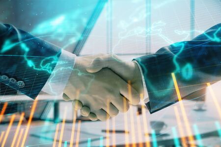 Multi exposure of financial chart and map on office background with two businessmen handshake. Concept of success in businessの写真素材