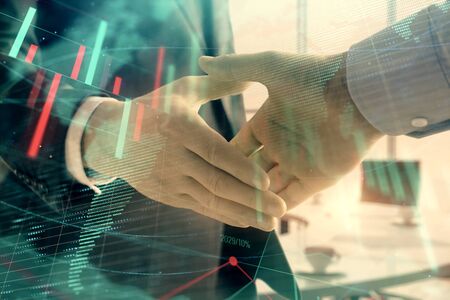 Multi exposure of financial chart and map on office background with two businessmen handshake. Concept of success in businessの写真素材