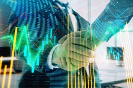 Multi exposure of financial chart and map on office background with two businessmen handshake. Concept of success in businessの写真素材