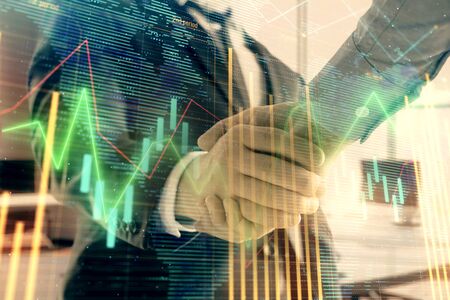 Multi exposure of financial chart and map on office background with two businessmen handshake. Concept of success in businessの写真素材