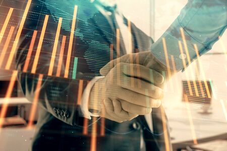 Multi exposure of financial chart and map on office background with two businessmen handshake. Concept of success in businessの写真素材