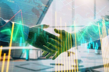 Multi exposure of financial chart and map on office background with two businessmen handshake. Concept of success in businessの写真素材