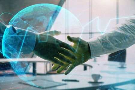 Multi exposure of financial chart and map on office background with two businessmen handshake. Concept of success in businessの写真素材